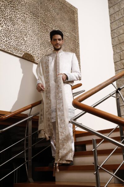 elegant white sherwani with embroidery on the front border, paired with a matching inner suit and a four-sided embroidered shawl, perfect for the modern groom.
