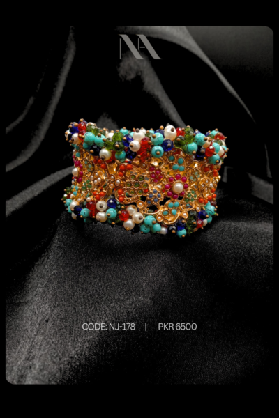 Wide gold cuff bracelet with detailed filigree, multicolored beads, and faux pearls. Bold bohemian statement jewelry for festive events.