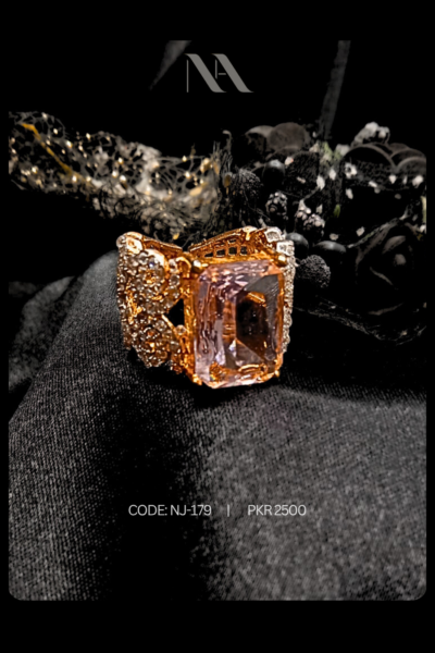 Rose gold statement ring with large rectangular rose-pink crystal. Vintage filigree detailing for an engagement or promise ring.