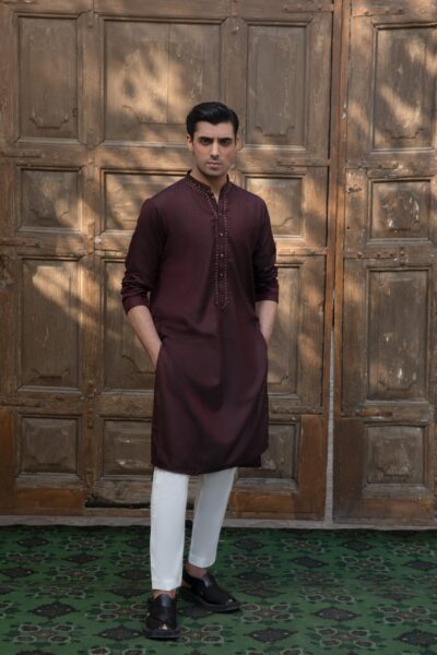 man wearing a luxury burgundy wine-toned kurta for men with subtle metallic beadwork on the collar,