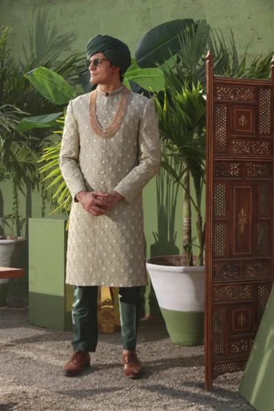 man wearing ALOE GREEN SHERWANI for groom PAIRED WITH BASIL GREEN INNER SUIT AND TURBAN on wedding day designed by naushemian by nauman arfeen