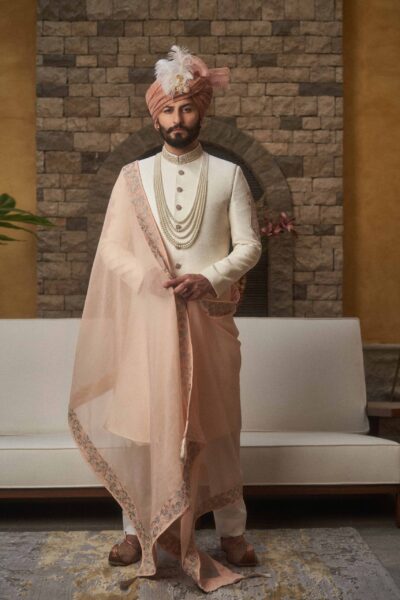 Groom wearing ANTIQUE WHITE SHERWANI PAIRED WITH LIGHT PEACH SHAWL AND TURBAN of naushemian by nauman arfeen