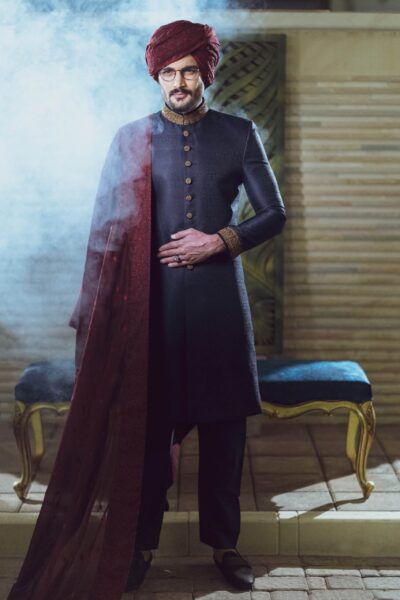 man wearing PRUSSIAN BLUE SHERWANI for groom on his wedding day WITH MATCHING INNER SUIT PAIRED WITH MAROON TURBAN AND SHAWL
