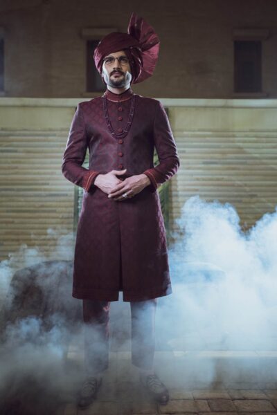 man wearing DARK MAROON SHERWANI PAIRED WITH MATCHING INNER SUIT, SHAWL AND TURBAN of naushemian by nauman arfeen on his wedding day