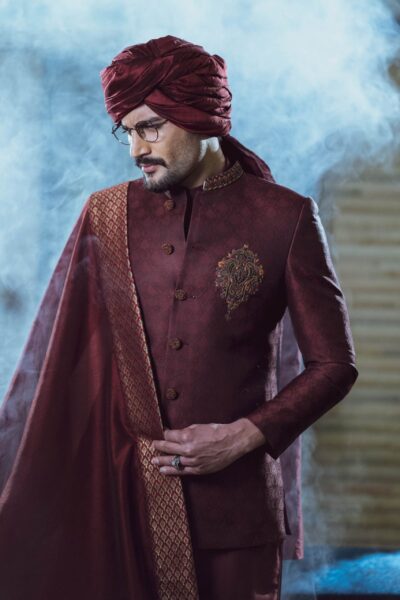 man wearing Dark MAROON SHERWANI for groom PAIRED WITH MATCHING INNER SUIT, SHAWL AND TURBAN designed by naushemian by nauman arfeen on wedding