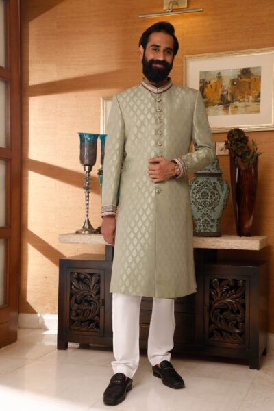 man wearing FERNWOOD GREEN SHERWANI for groom PAIRED WITH WHITE INNER SUIT designed by naushemian by nauman arfeen on wedding day