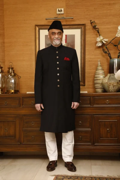 man wearing BLACK SHERWANI PAIRED WITH WHITE INNER SUIT AND TURBAN designed by naushemian by nauman arfeen on wedding day