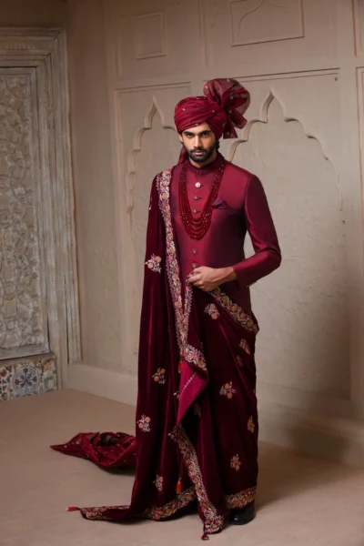 man wearing DEEP MAROON SHERWANI for groom PAIRED WITH MATCHING INNER SUIT, SHAWL AND TURBAN designed by naushemian by nauman arfeen on wedding day