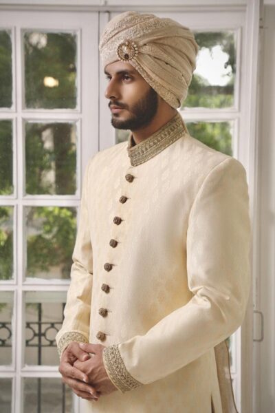 Man wearing HAZE GOLD SHERWANI PAIRED WITH MATCHING INNER SUIT AND TURBAN on his wedding day