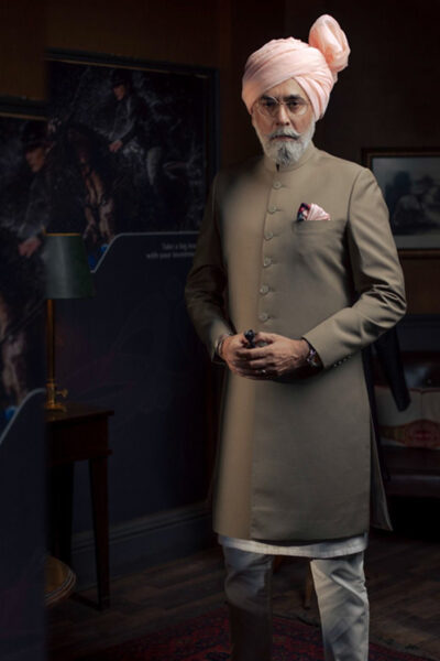 man wearing KHAKI COLOURED SHERWANI for father of bride or father of groom paired WITH WHITE INNER SUIT PAIRED WITH PASTEL PEACH TURBAN designed by naushemian by nauman arfeen on wedding day