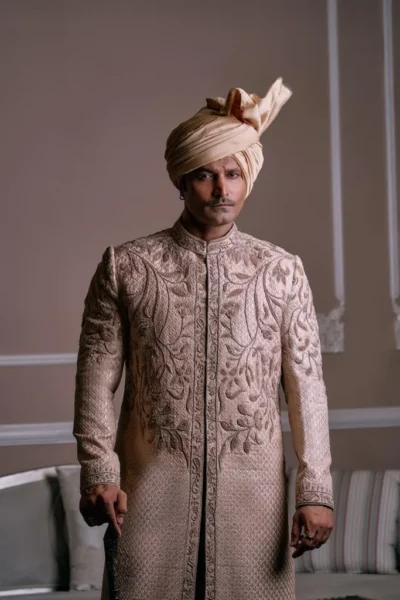 man wearing gold Sherwani for groom with matching inner suit and turban of naushemian by nauman arfeen