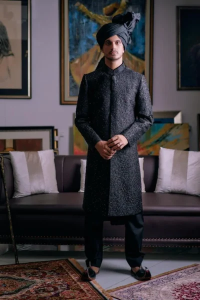 Man wearing COOL BLACK SHERWANI for groom PAIRED WITH MATCHING INNER SUIT AND TURBAN - Pakistani Black Sherwani for men - designer sherwani for wedding - Naushemian by Nauman Arfeen