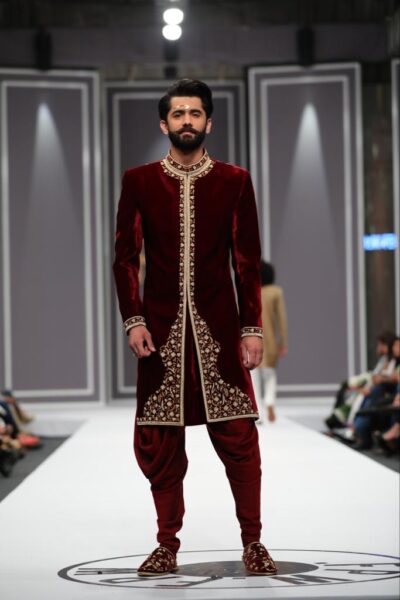 man wearing DEEP MAROON SHERWANI for groom PAIRED WITH MATCHING INNER SUIT, SHAWL AND TURBAN designed by naushemian by nauman arfeen on wedding day