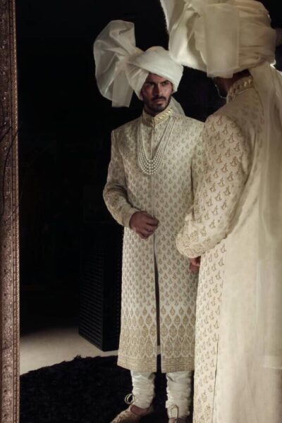 Beige Sherwani of Naushemian by Nauman Arfeen , with its matching inner suit and turban, radiates timeless charm.