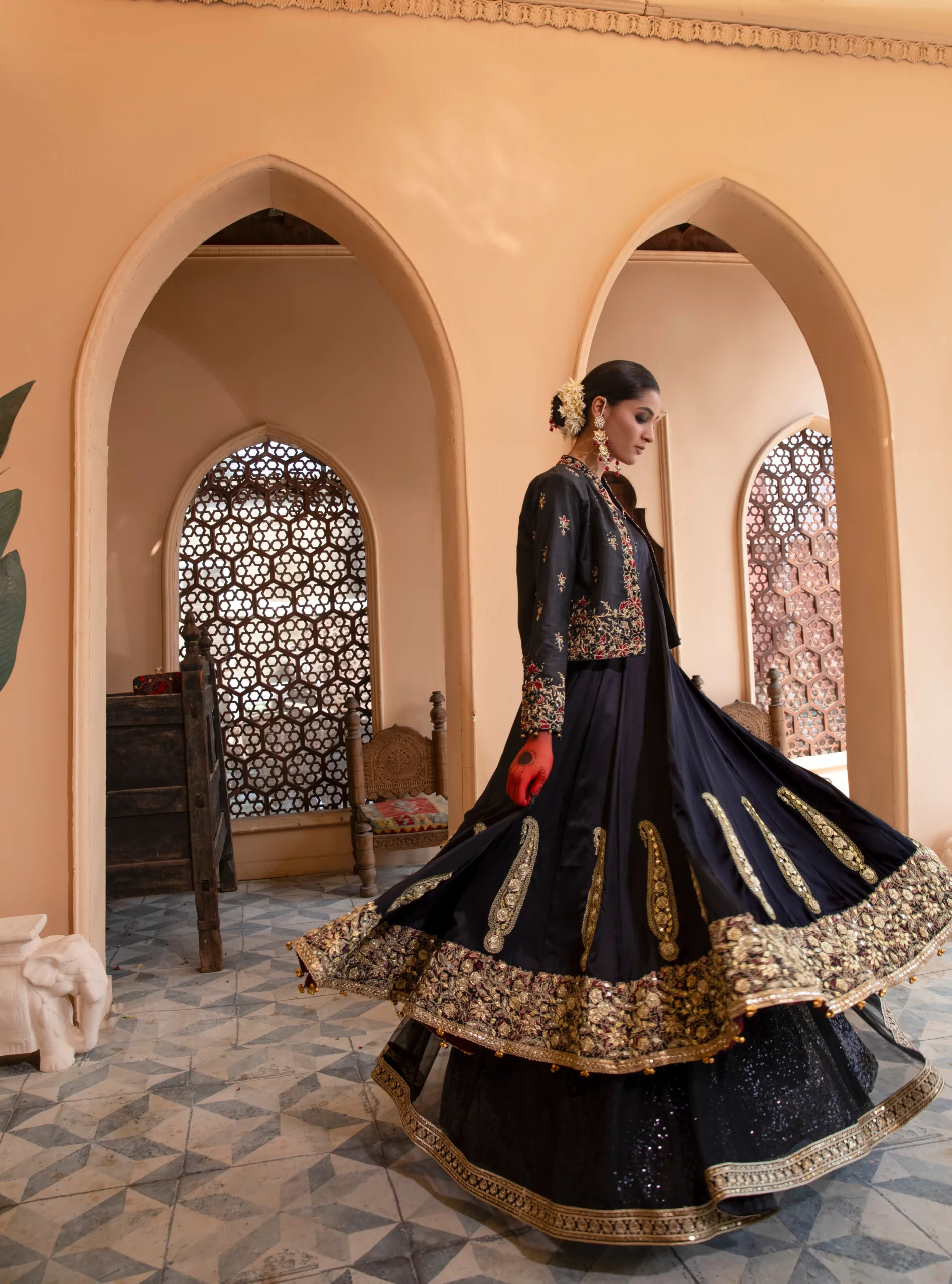 B612_20240419_185333_871 A luxurious black dress with cascading net layers, adorned with intricate embroidery and gota kinara work