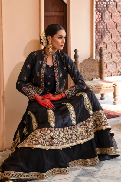 A luxurious black dress with cascading net layers, adorned with intricate embroidery and gota kinara work