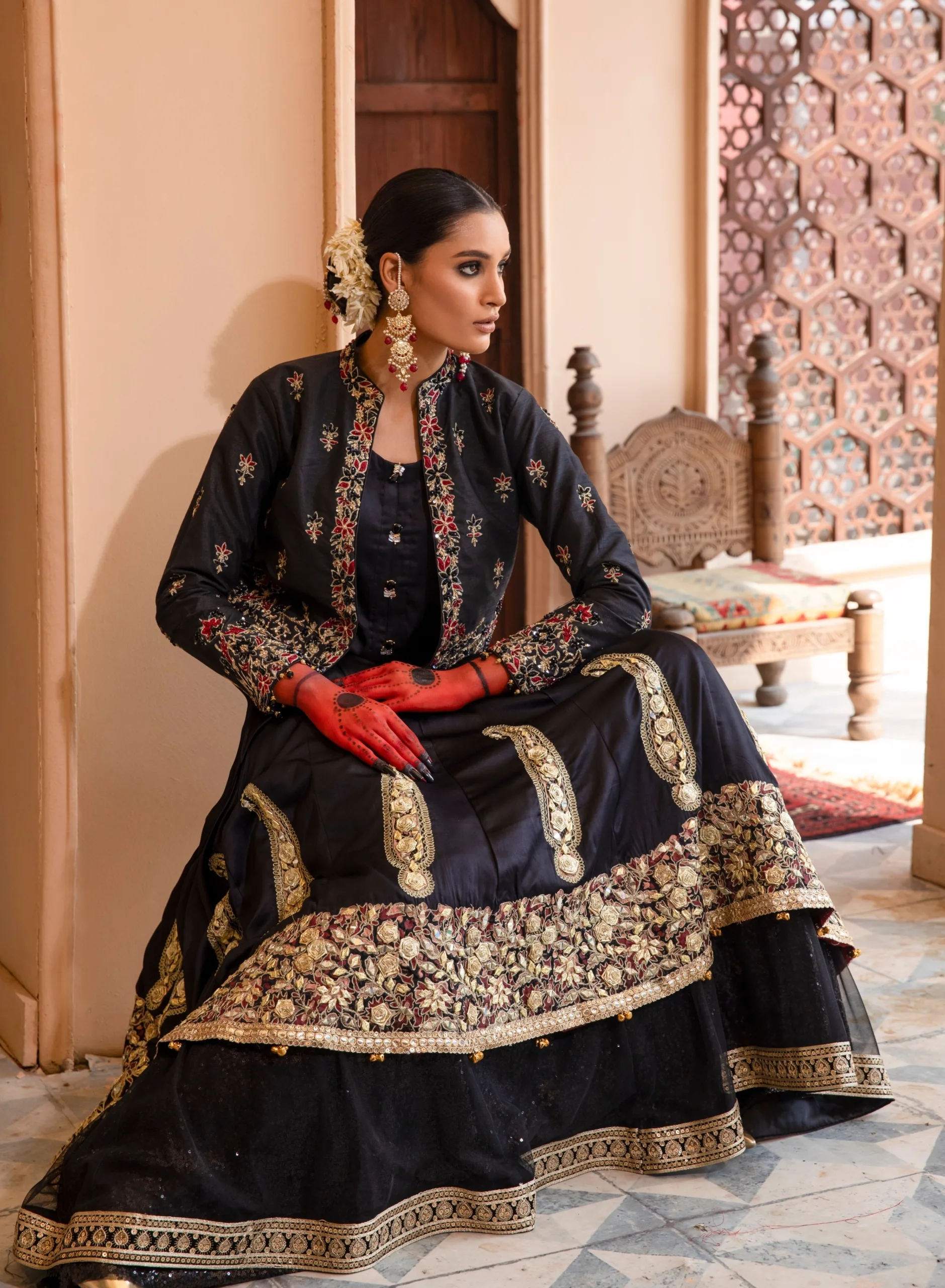 B612_20240419_185631_137 A luxurious black dress with cascading net layers, adorned with intricate embroidery and gota kinara work