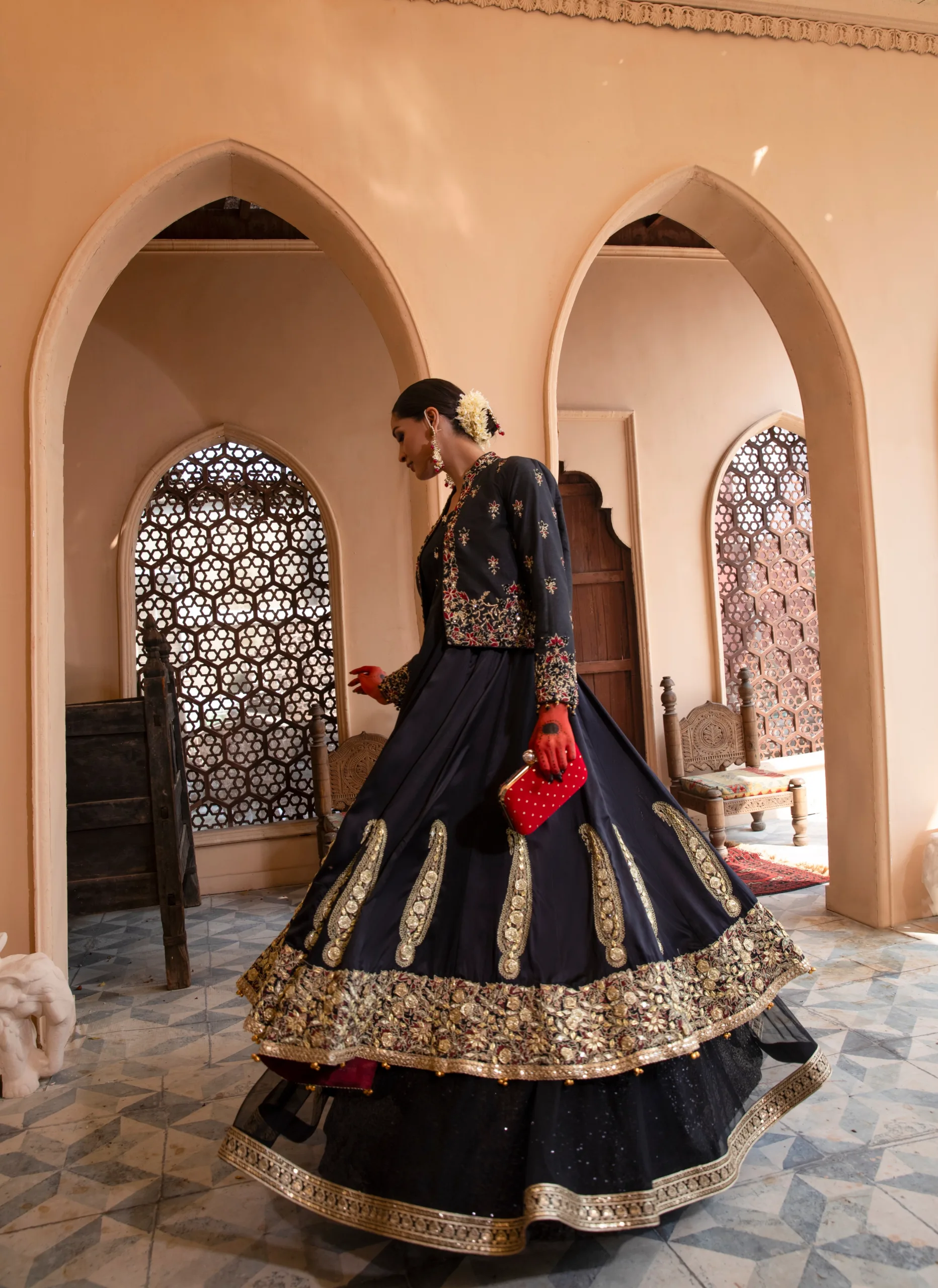 B612_20240419_185811_176 A luxurious black dress with cascading net layers, adorned with intricate embroidery and gota kinara work