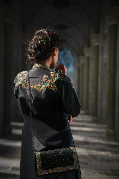 Noir Étoilé Black Embellished Couture Coat Gown Set featuring a floor-length black coat with intricate crystal embroidery on the shoulders, high neckline, hand embellishments, textured flowing gown, and embellished back detailing.