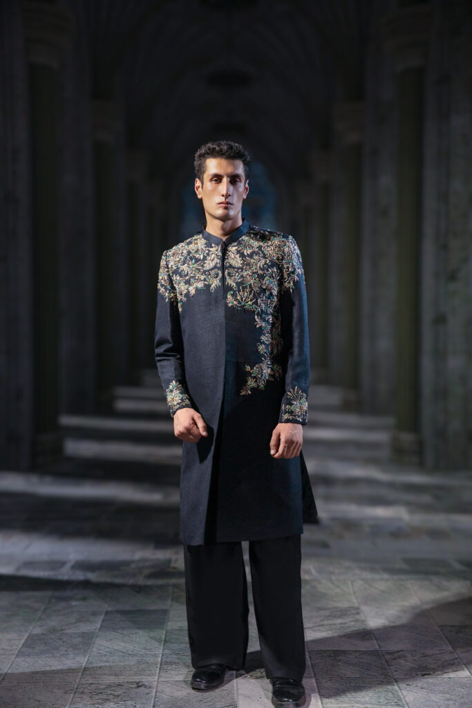 Astral Heirloom Black Embellished Couture Sherwani Set featuring ornate hand embroidery across the shoulders and chest, embroidered cuffs, structured band collar, tailored black trousers, and embellished upper-back detailing. ÉTOILE collection by Nauman Arfeen is a story chosen to tell through fabric, craftsmanship, light and emotion. The Genesis is the first chapter of a five-part journey