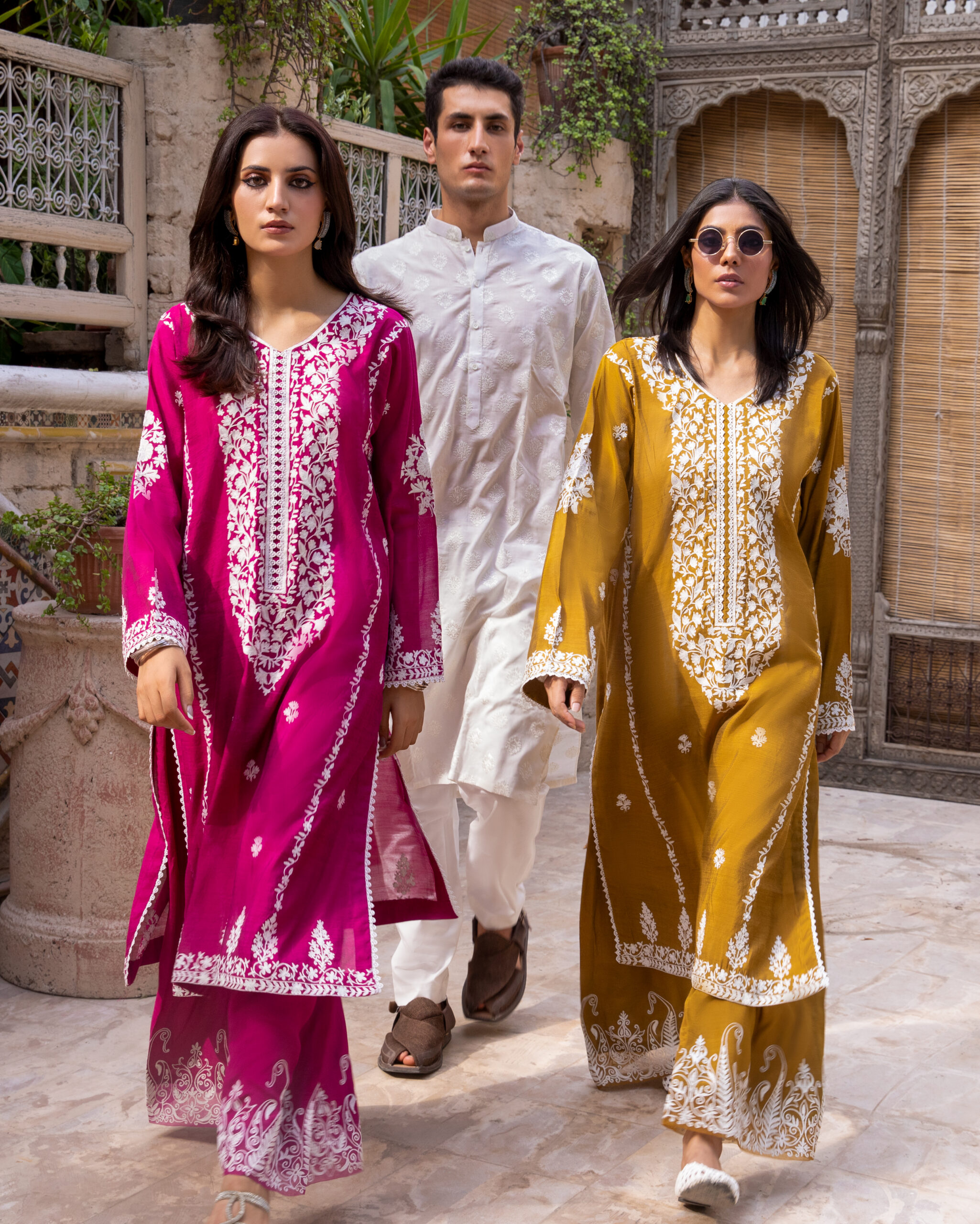 C76A6947 Rich mustard-coloured kurta Intricate white floral embroidery Elegant V-shaped embroidered neckline Full-length long kurta silhouette Embroidered sleeves and statement cuffs Scattered floral motifs on the kurta Detailed embroidered side borders Ornate embroidered kurta hem Wide-leg trousers Embroidered trouser hem Coordinated two-piece ensemble Suitable for festive and cultural occasions Elegant option for daytime and evening gatherings Contemporary silhouette with traditional detailing