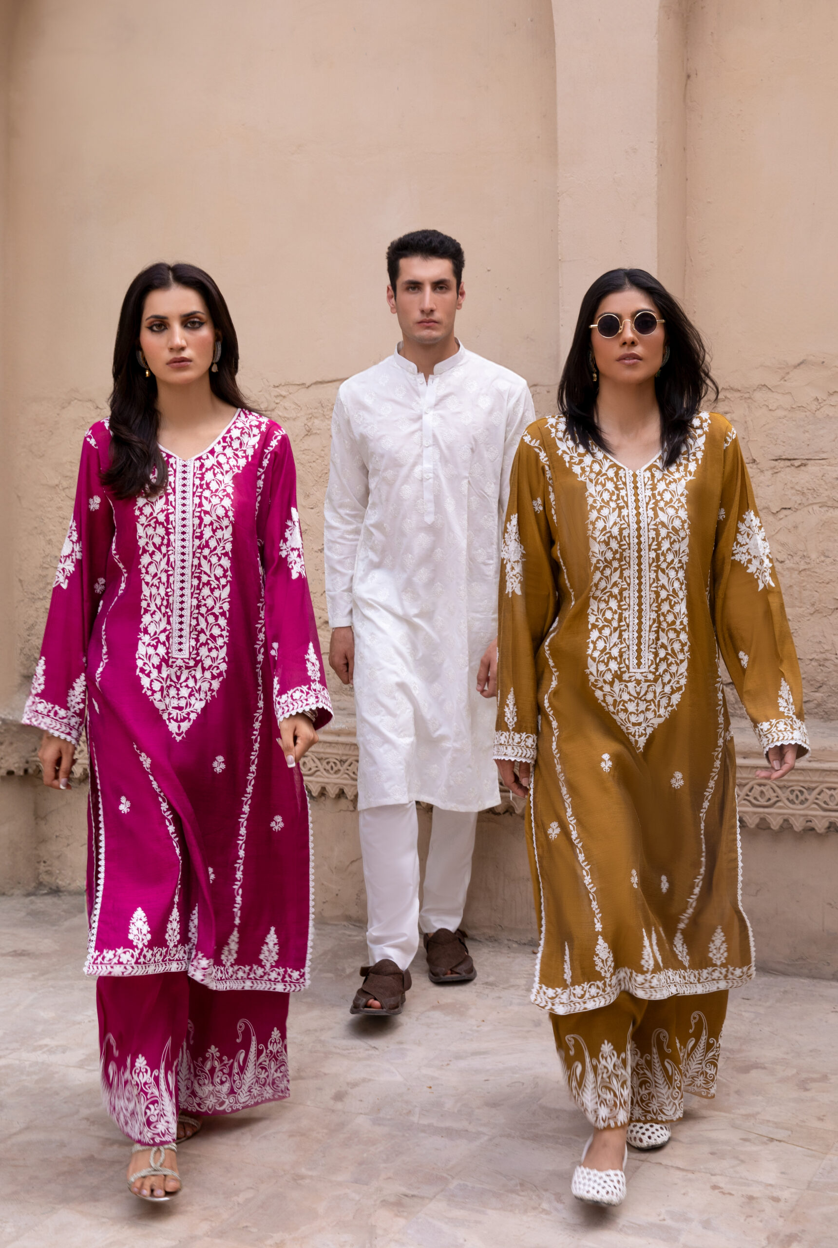C76A6951 Rich mustard-coloured kurta Intricate white floral embroidery Elegant V-shaped embroidered neckline Full-length long kurta silhouette Embroidered sleeves and statement cuffs Scattered floral motifs on the kurta Detailed embroidered side borders Ornate embroidered kurta hem Wide-leg trousers Embroidered trouser hem Coordinated two-piece ensemble Suitable for festive and cultural occasions Elegant option for daytime and evening gatherings Contemporary silhouette with traditional detailing