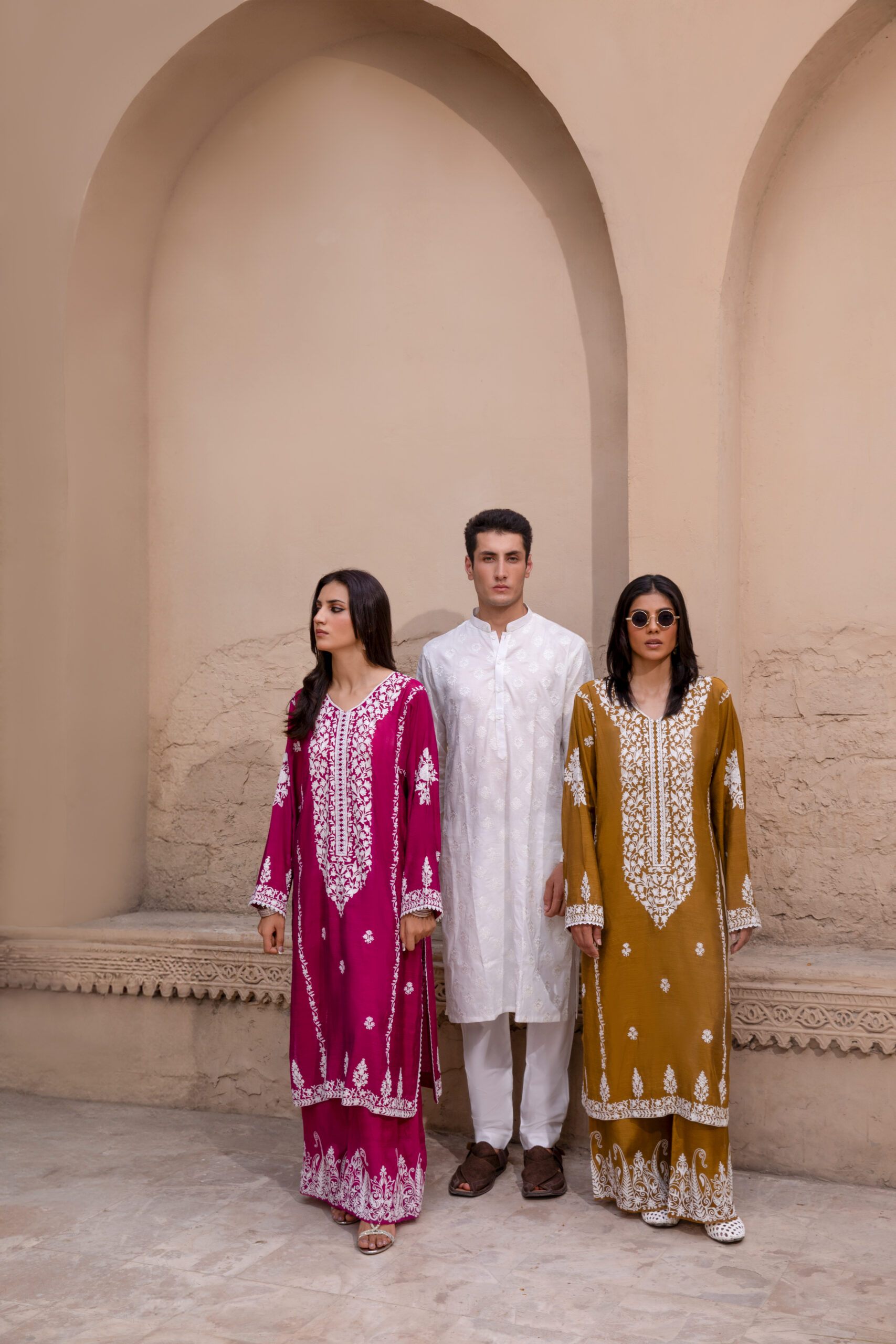 C76A6955 Rich mustard-coloured kurta Intricate white floral embroidery Elegant V-shaped embroidered neckline Full-length long kurta silhouette Embroidered sleeves and statement cuffs Scattered floral motifs on the kurta Detailed embroidered side borders Ornate embroidered kurta hem Wide-leg trousers Embroidered trouser hem Coordinated two-piece ensemble Suitable for festive and cultural occasions Elegant option for daytime and evening gatherings Contemporary silhouette with traditional detailing