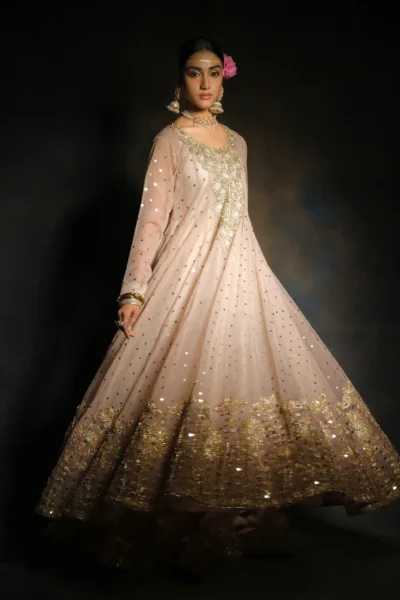 bride wearing Peach Wedding Gown with heavy embroidered gold neck work, mirror work on the full frock, and a heavily embroidered dupatta with floral lace work and heavy borders.