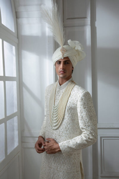 Pakistani groom wedding sherwani by Naushemian Nauman Arfeen – Divinus masterpiece design featuring intricate Kora embroidery, filigree detailing, embroidered shawl, regal turban, and handcrafted Khoosa shoes for luxury weddings