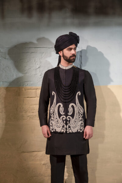 This raw silk black waistcoat is a timeless expression of refined style. The smooth fabric offers a luxurious finish, while the delicate white collar embroidery adds a touch of sophistication and modern artistry. Perfect for pairing with traditional kurta-pajama or formal attire, it is designed for the gentleman who values elegance, versatility, and cultural heritage. A piece that effortlessly transitions from wedding celebrations to formal evenings, making it an essential addition to every refined wardrobe.