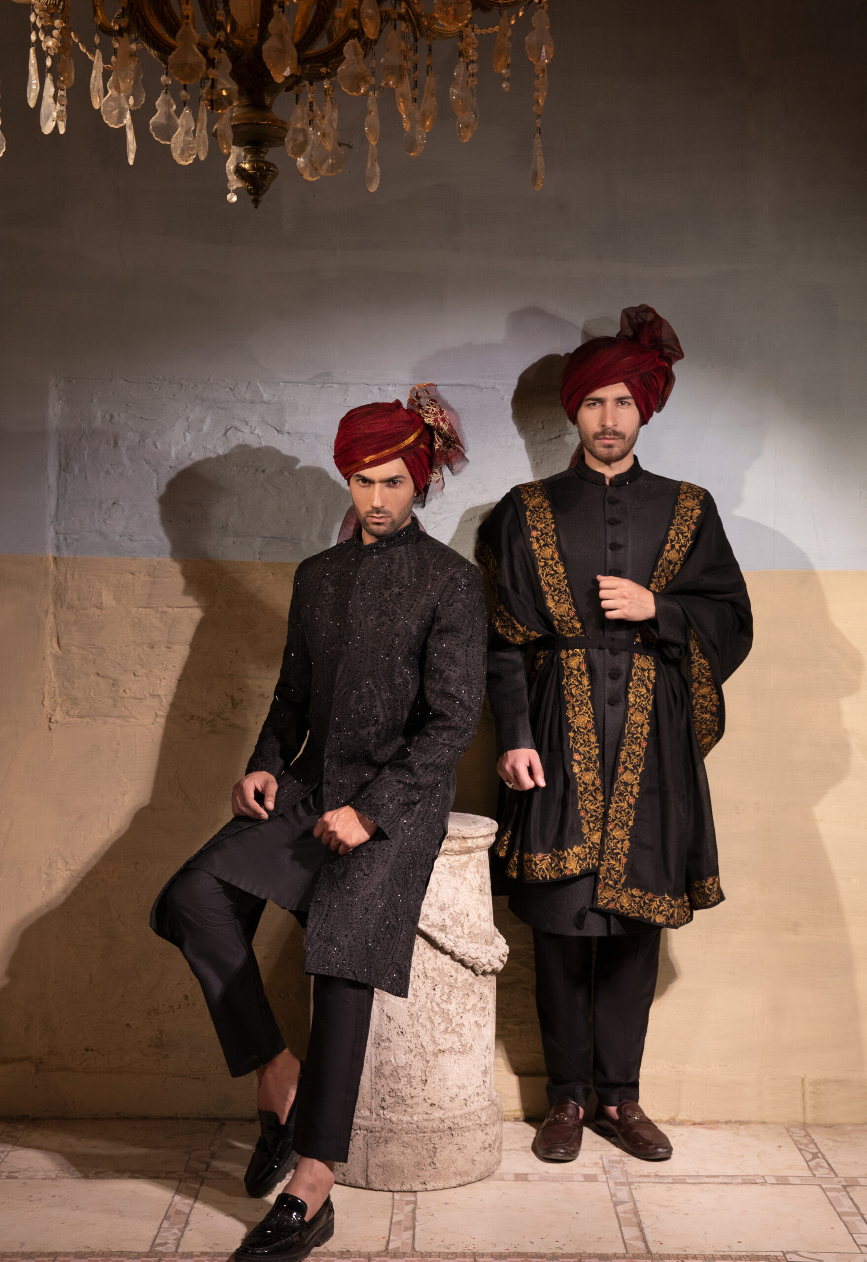 Artisan crafted black sherwani with embroidered collar and buttons, paired with black-maroon-gold shawl and maroon turban