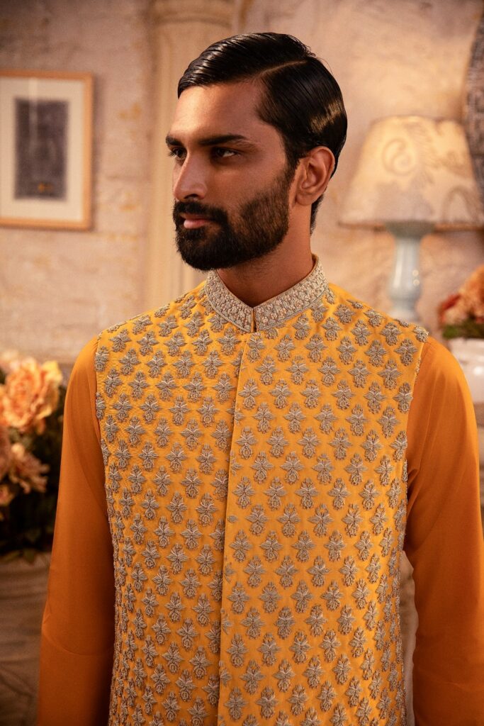 man wearing canary yellow waistcoat designed by nauman arfeen on his mehendi event paired with matching kurta pajama