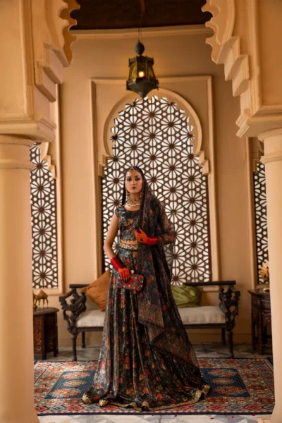 This radiant black lehenga seamlessly blends contemporary style with timeless elegance. The shimmering net fabric creates a captivating base, adorned with delicate floral embroidery in muted tones. The intricate border embroidery adds a touch of tradition, while the short, sleeveless choli brings a modern edge. This breathtaking ensemble is perfect for making a statement at any special occasion.