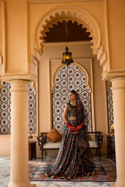 This radiant black lehenga seamlessly blends contemporary style with timeless elegance. The shimmering net fabric creates a captivating base, adorned with delicate floral embroidery in muted tones. The intricate border embroidery adds a touch of tradition, while the short, sleeveless choli brings a modern edge. This breathtaking ensemble is perfect for making a statement at any special occasion.